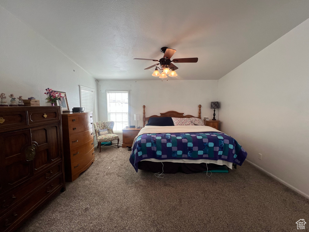 Bedroom featuring light carpet, ceiling fan, vaulted ceiling, and baseboards