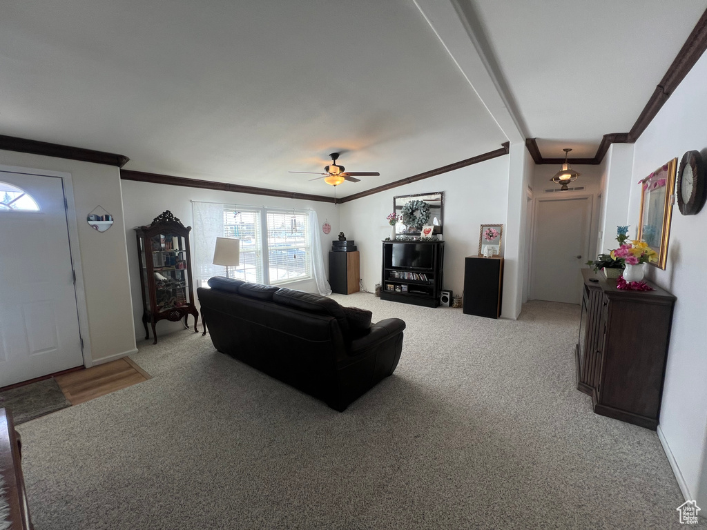 Living room with ornamental molding, light carpet, and ceiling fan