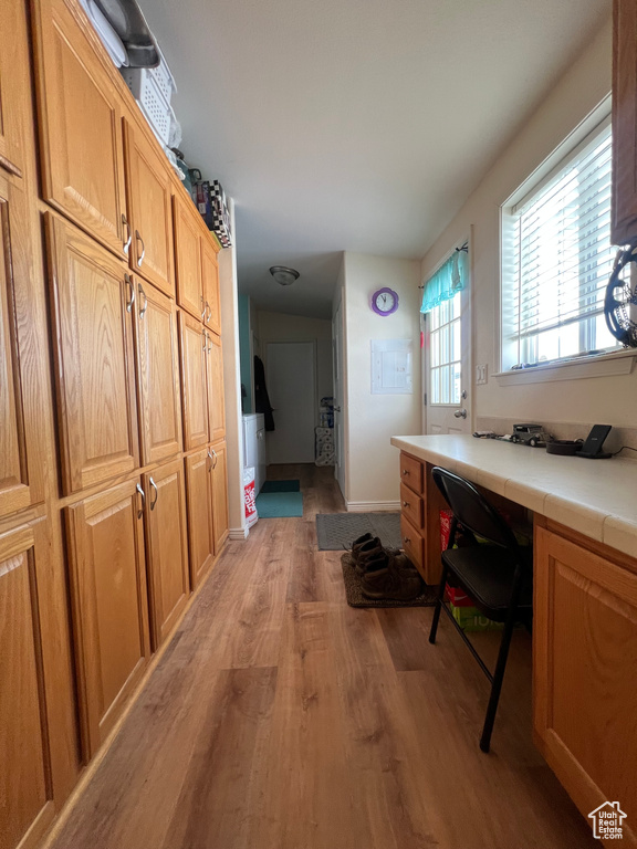 Interior space featuring light wood-type flooring, baseboards, and built in study area