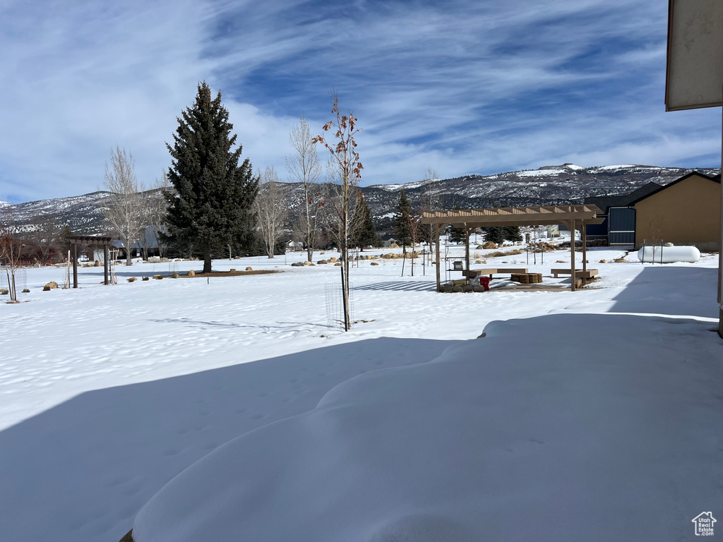 Snowy yard featuring a mountain view