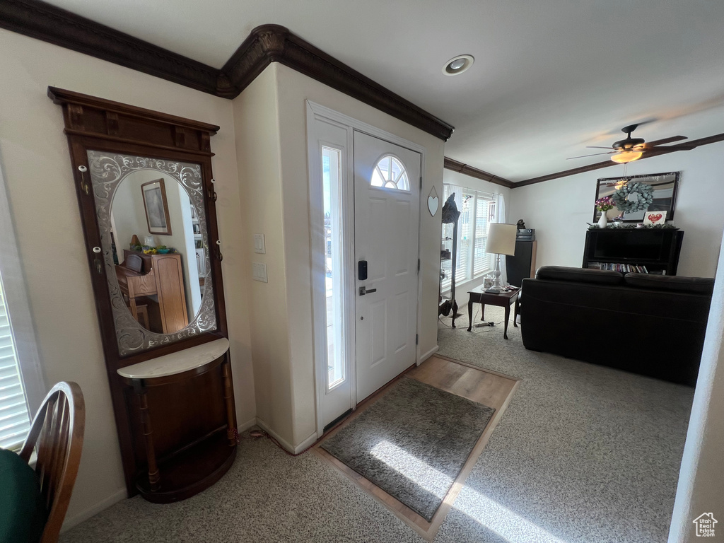 Foyer featuring baseboards, a ceiling fan, and crown molding