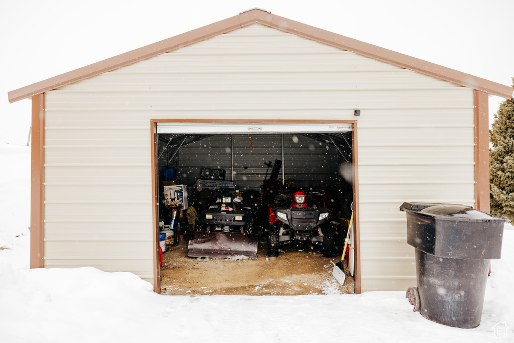Snow covered garage with a garage