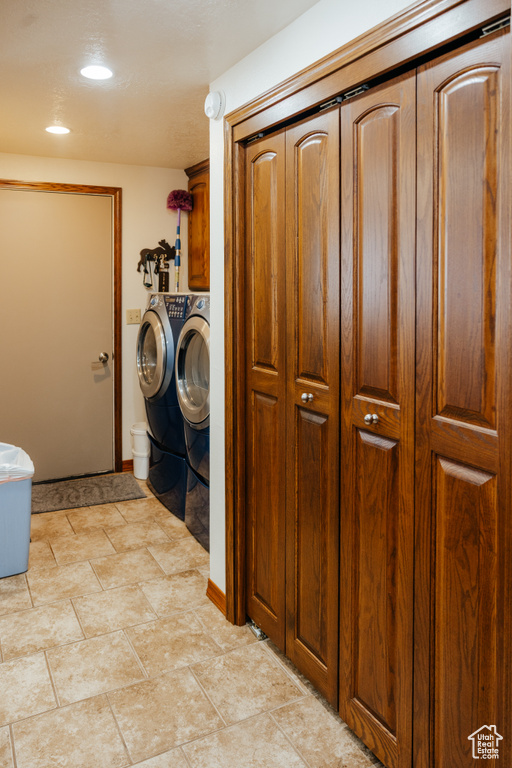 Washroom with cabinet space, washer and clothes dryer, and recessed lighting