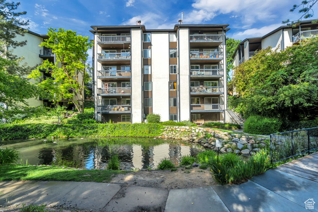 View of building exterior with a water view and fence