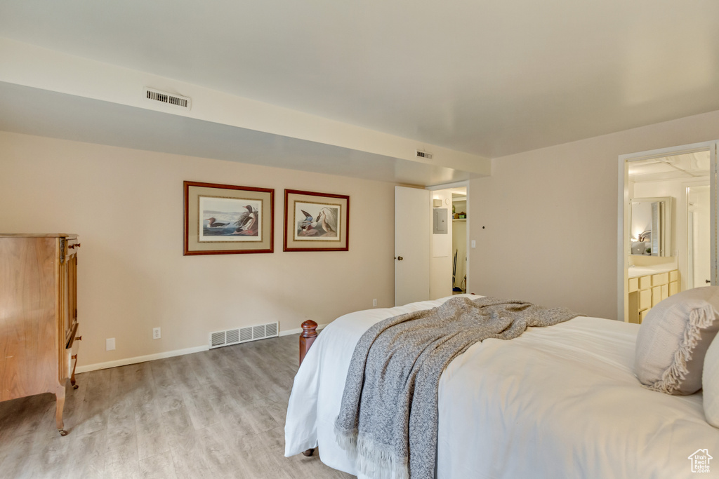 Bedroom with light wood-style floors, visible vents, and baseboards