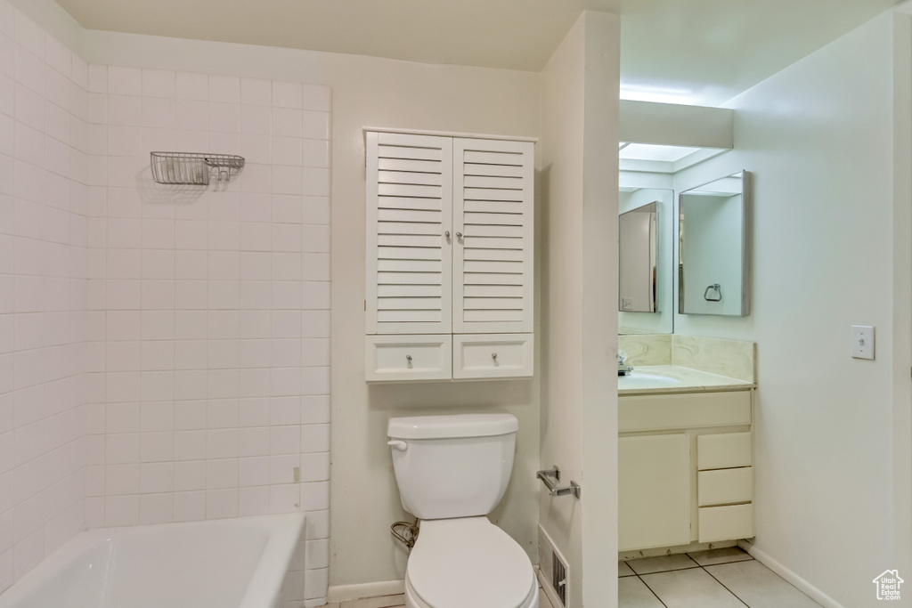 Bathroom with toilet, vanity, baseboards, shower / washtub combination, and tile patterned floors
