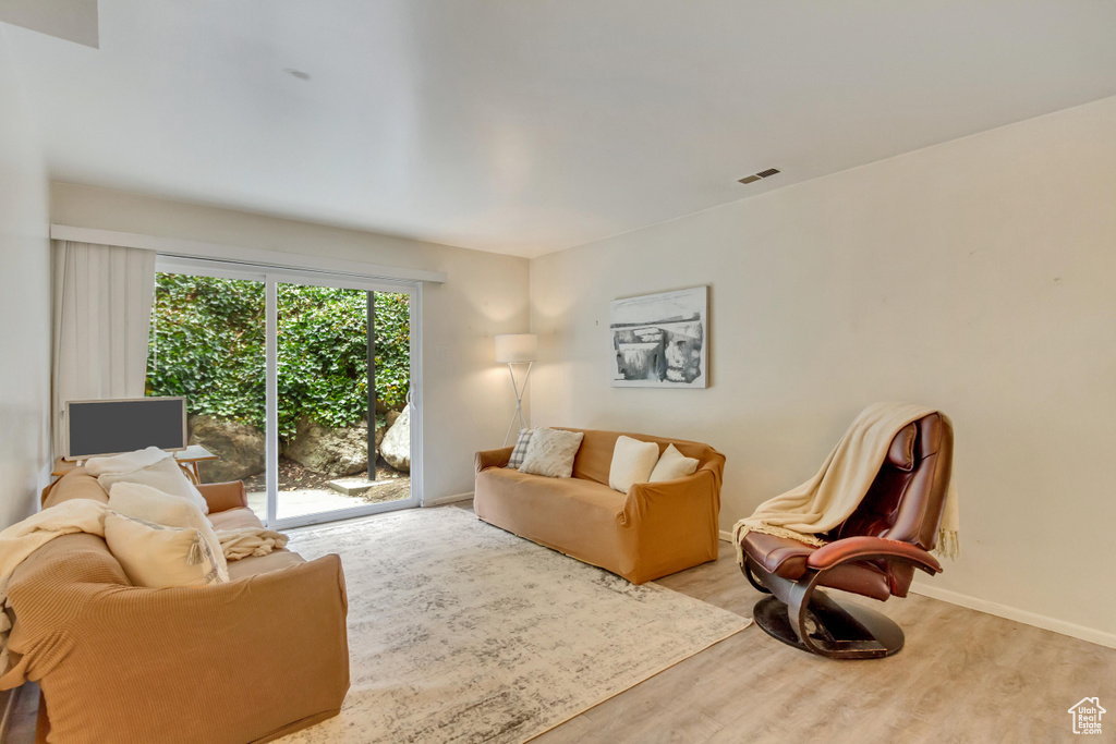 Living area featuring light wood-style floors, baseboards, and visible vents