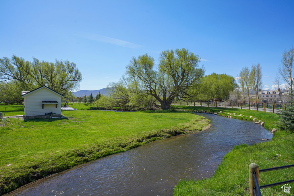 View of water feature featuring a mountain view and fence
