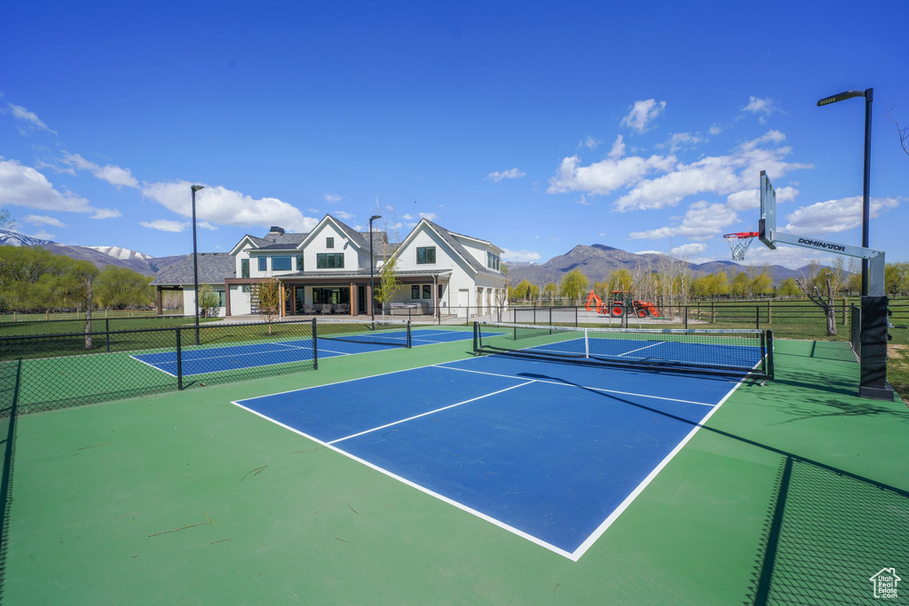 View of sport court featuring fence and a mountain view