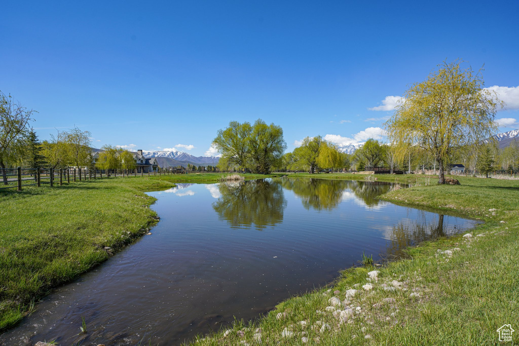 Property view of water featuring a mountain view and fence