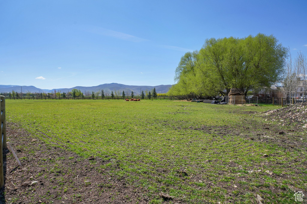 View of yard featuring fence, a rural view, and a mountain view