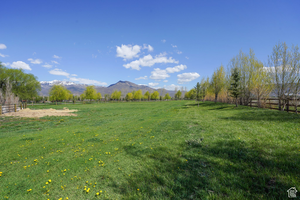 View of yard with a mountain view, a rural view, and fence