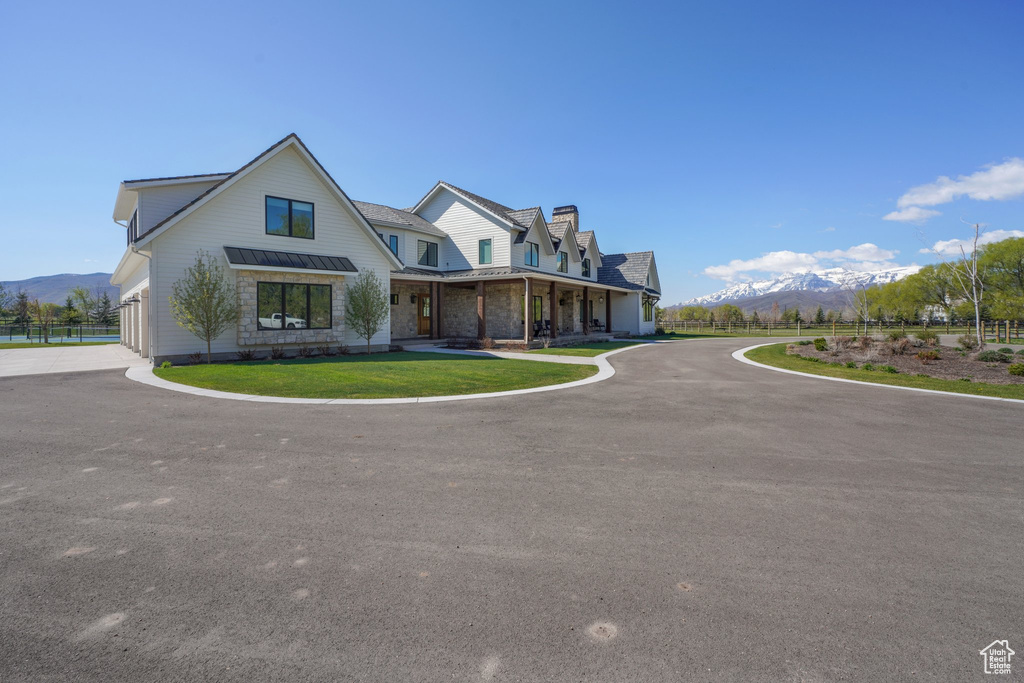 Modern inspired farmhouse featuring a mountain view, a chimney, metal roof, and a standing seam roof