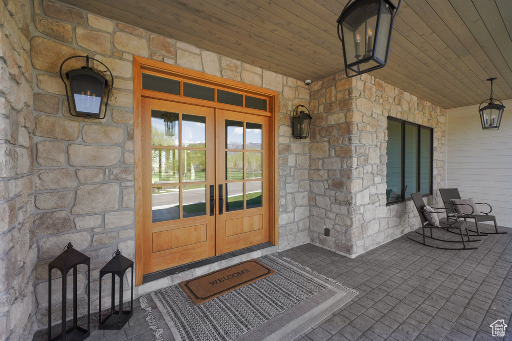 View of exterior entry with stone siding and french doors