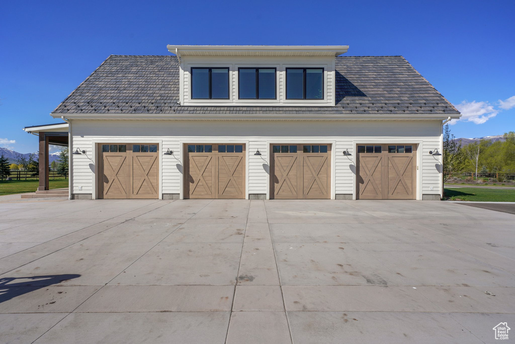 Garage featuring concrete driveway and a mountain view