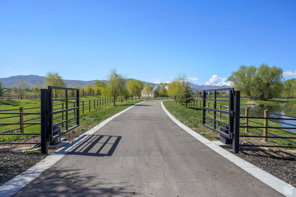 View of street with a water and mountain view, a rural view, a gated entry, and driveway
