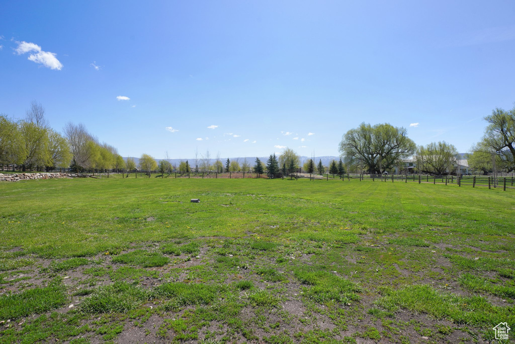 View of yard featuring a rural view and fence