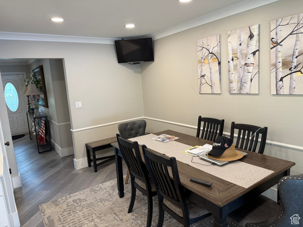 Dining area with ornamental molding, wood finished floors, recessed lighting, and baseboards