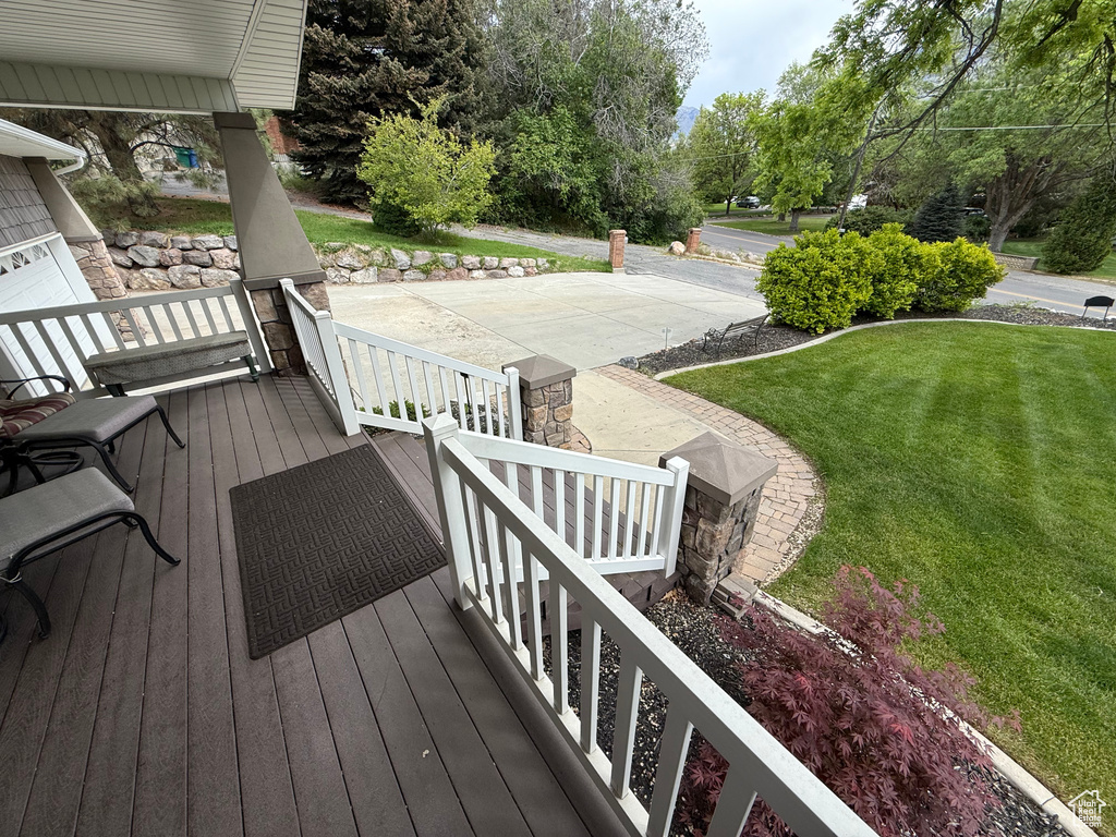 Wooden deck with covered porch and a yard