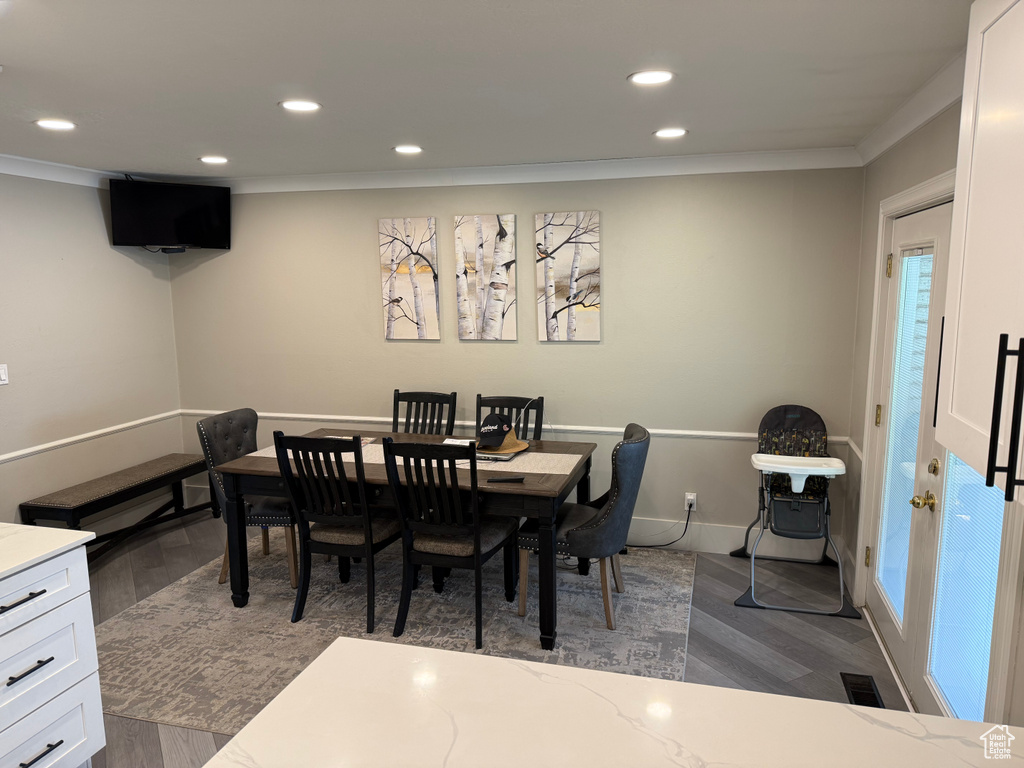 Dining room with ornamental molding, recessed lighting, dark wood finished floors, and baseboards
