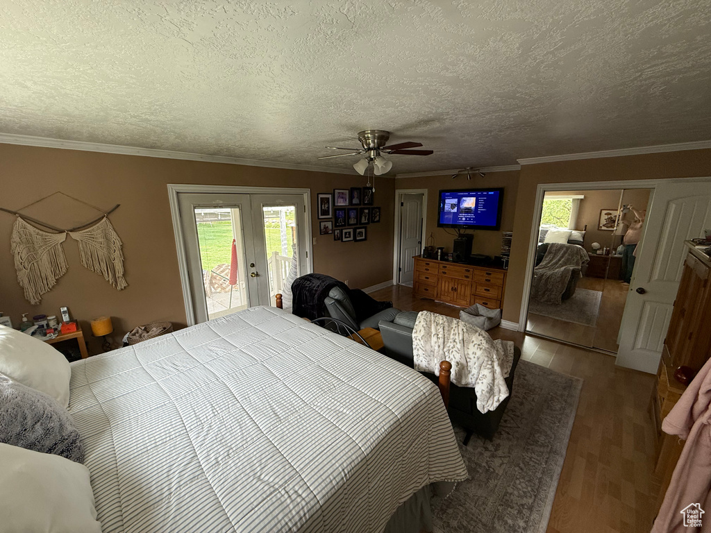 Bedroom featuring french doors, access to outside, wood finished floors, crown molding, and ceiling fan