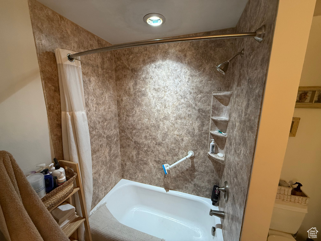 Bathroom featuring shower / tub combo and toilet