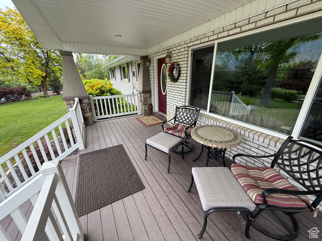 Wooden deck with covered porch and a lawn