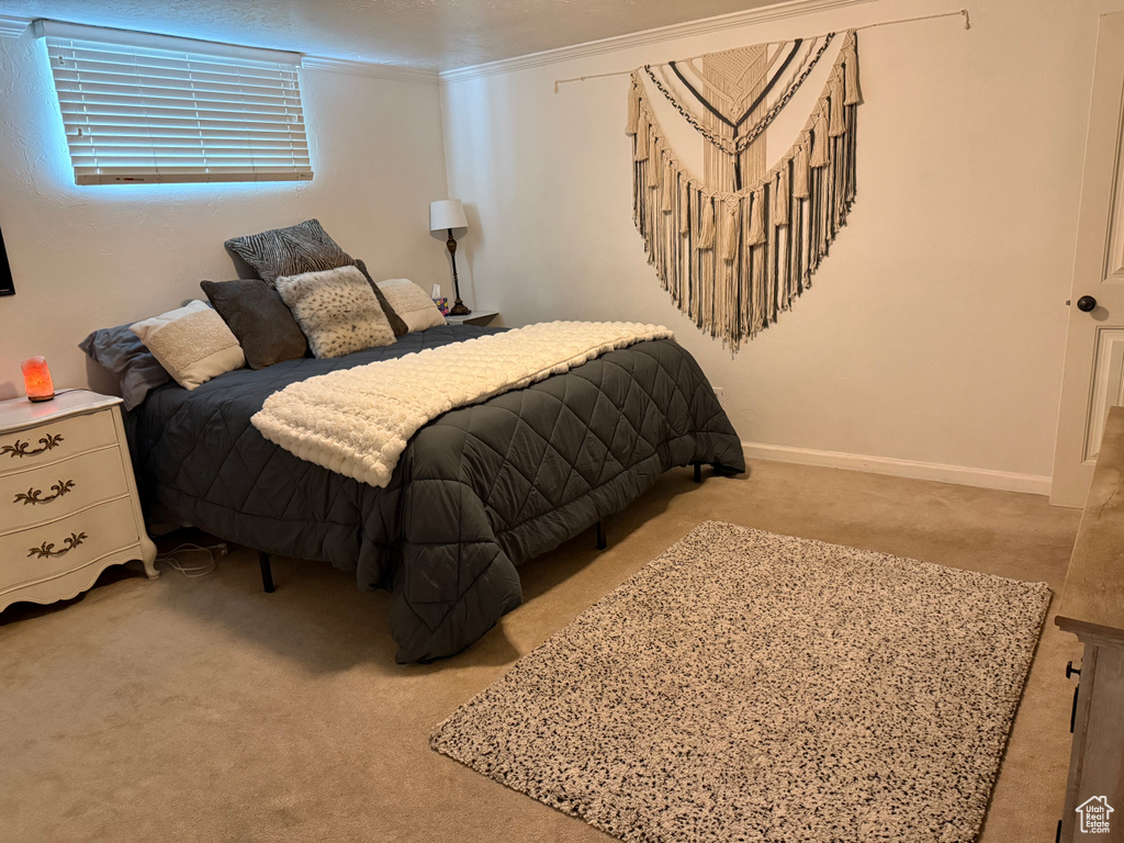 Bedroom featuring carpet floors, baseboards, and crown molding