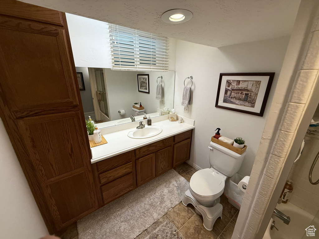 Full bathroom with toilet, vanity, and shower / tub combo