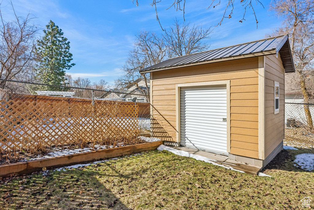View of outbuilding featuring an outbuilding and fence