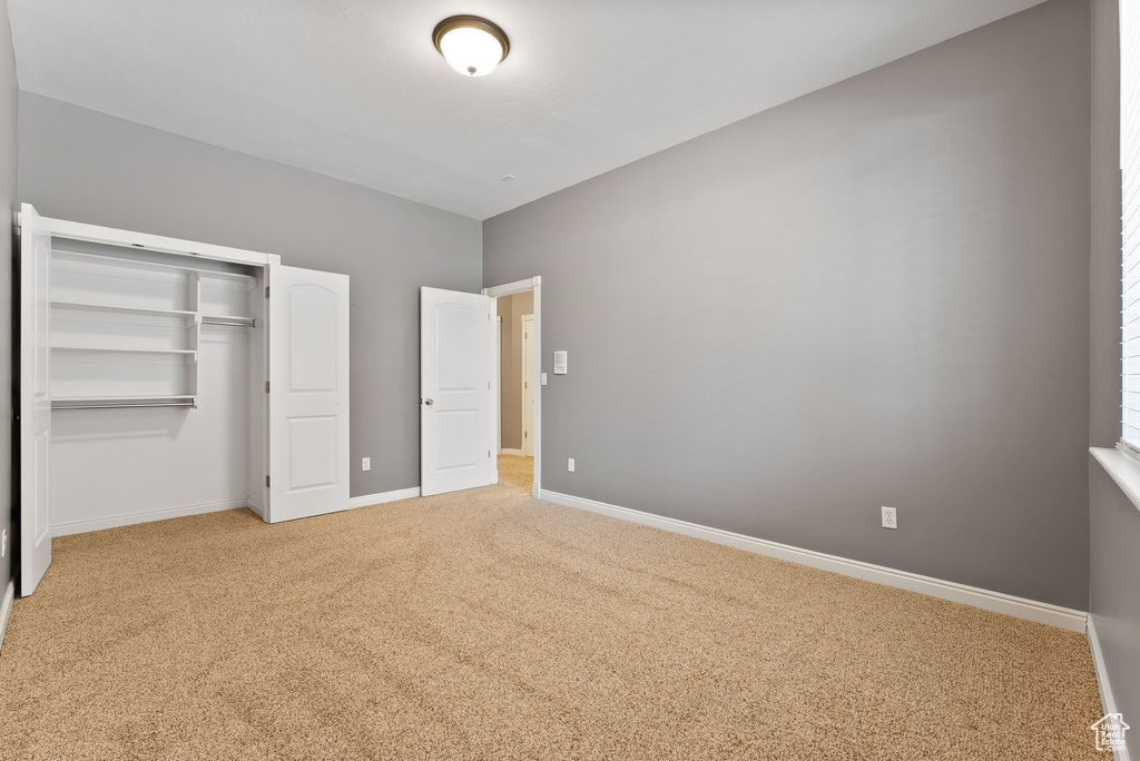 Unfurnished bedroom with a closet, baseboards, and carpet flooring