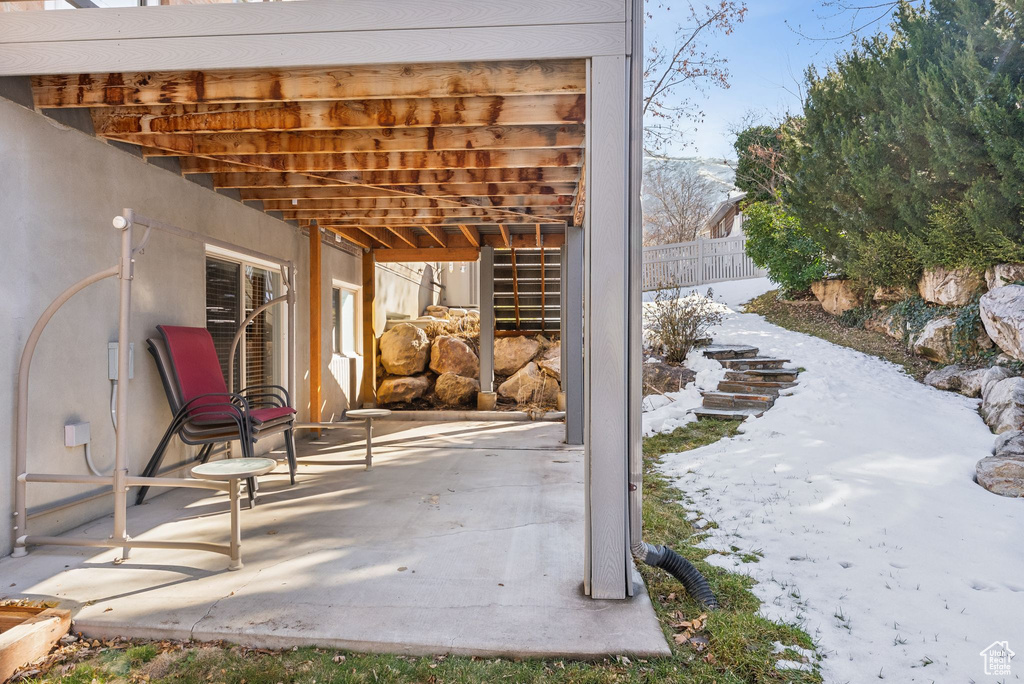 Snow covered patio with fence
