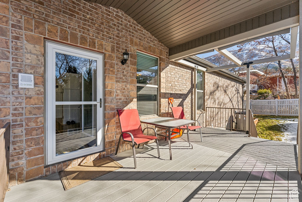 Wooden deck featuring glass enclosure and fence