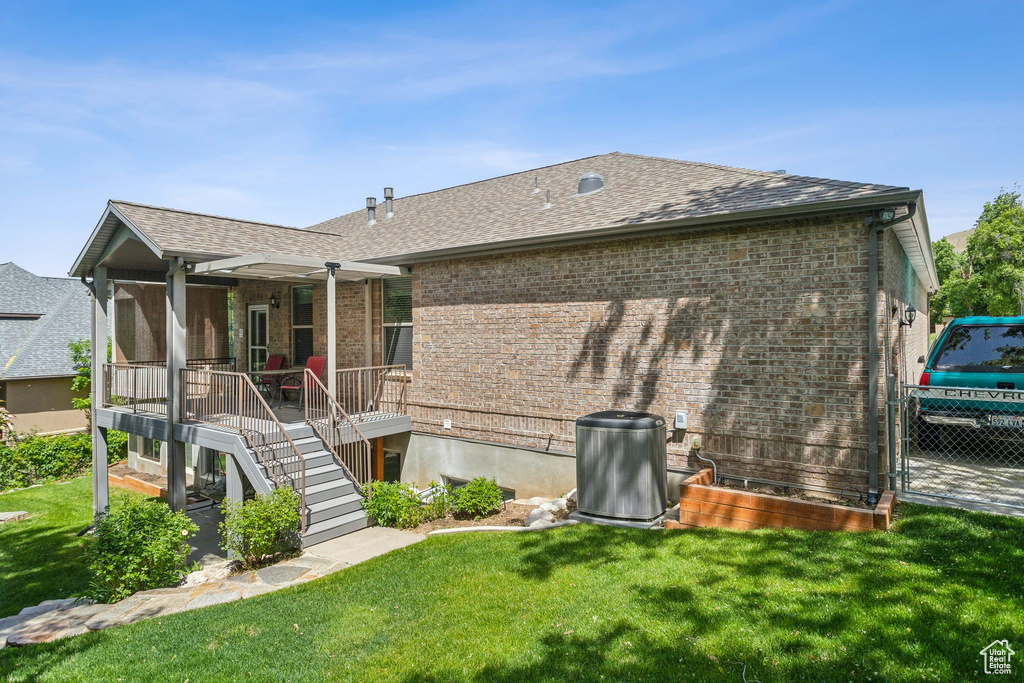 Back of property with brick siding, a shingled roof, and a porch