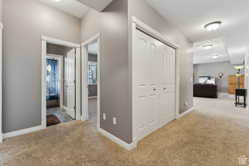 Hallway featuring carpet floors and baseboards