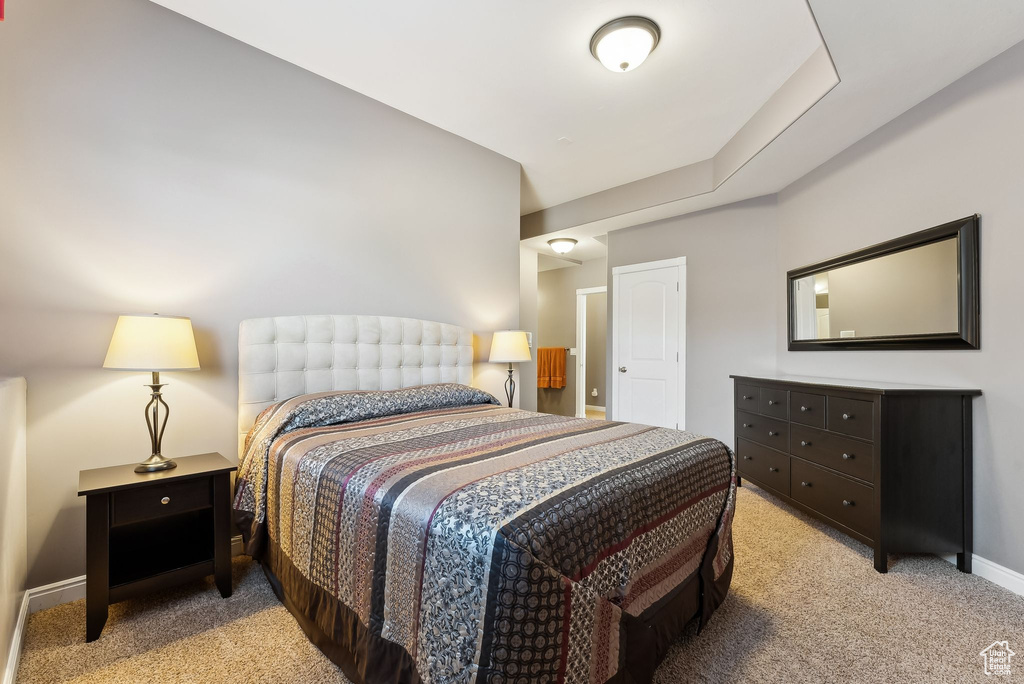 Bedroom featuring light carpet and baseboards