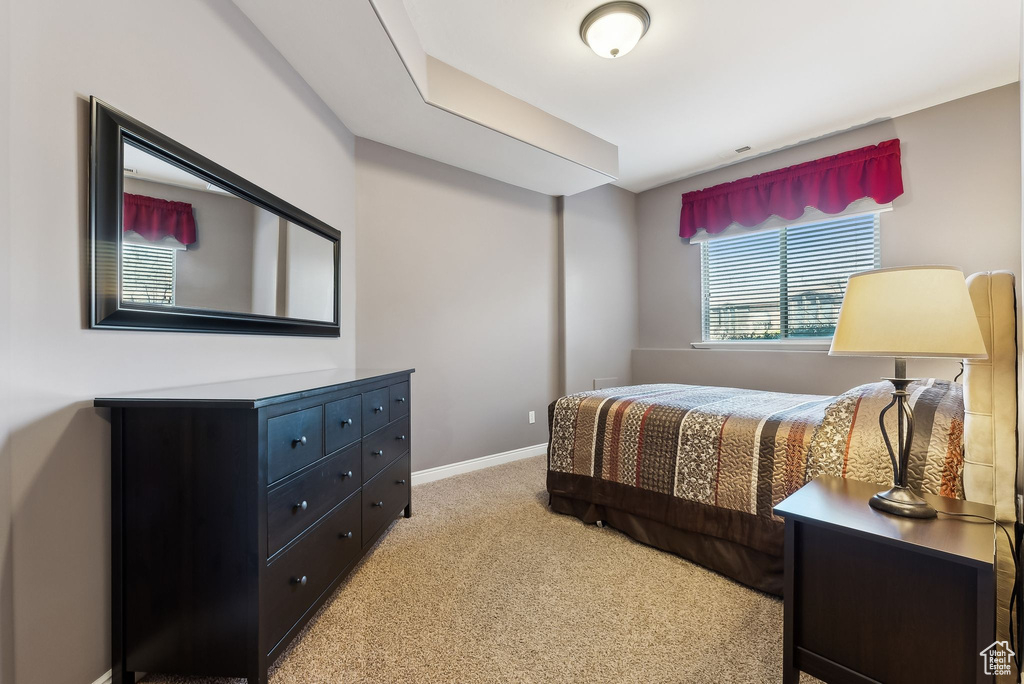 Bedroom with baseboards and light colored carpet