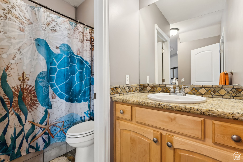 Bathroom with toilet, tasteful backsplash, and vanity