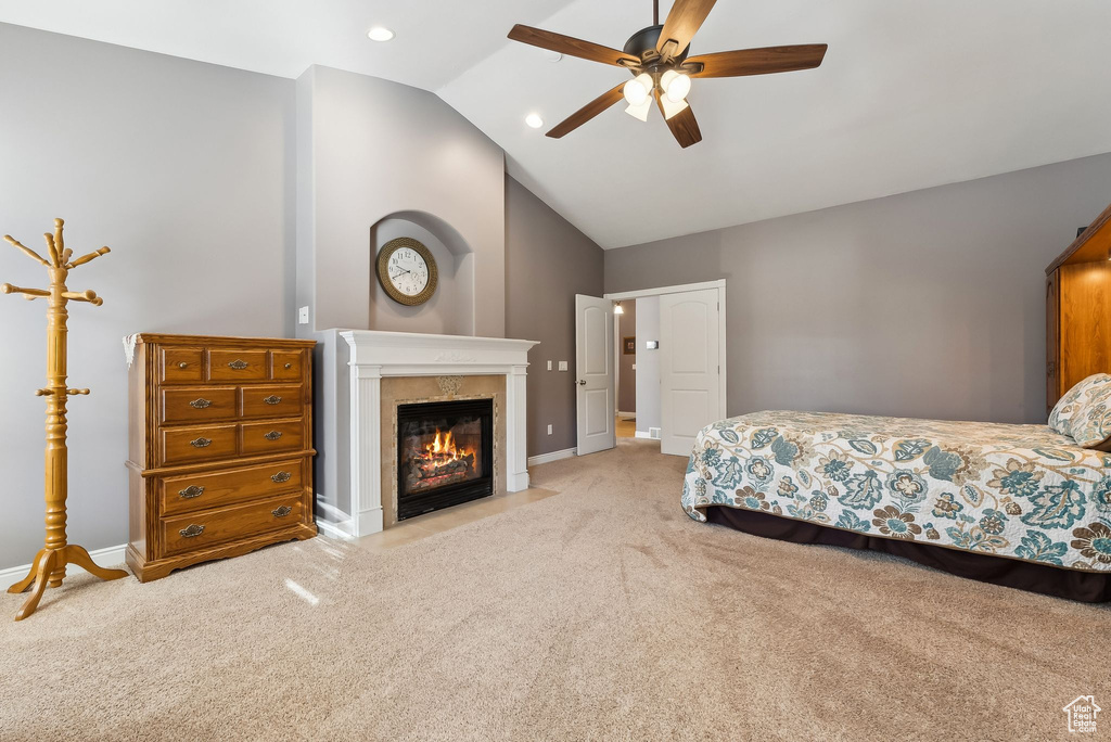 Bedroom with lofted ceiling, a fireplace, baseboards, and light colored carpet