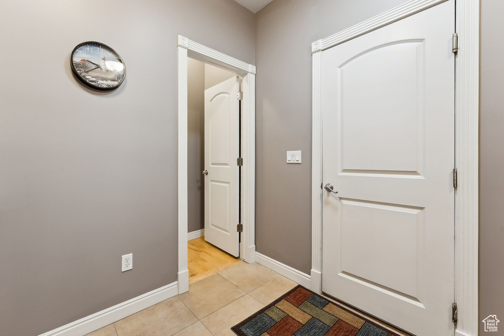 Hallway featuring light tile patterned floors and baseboards