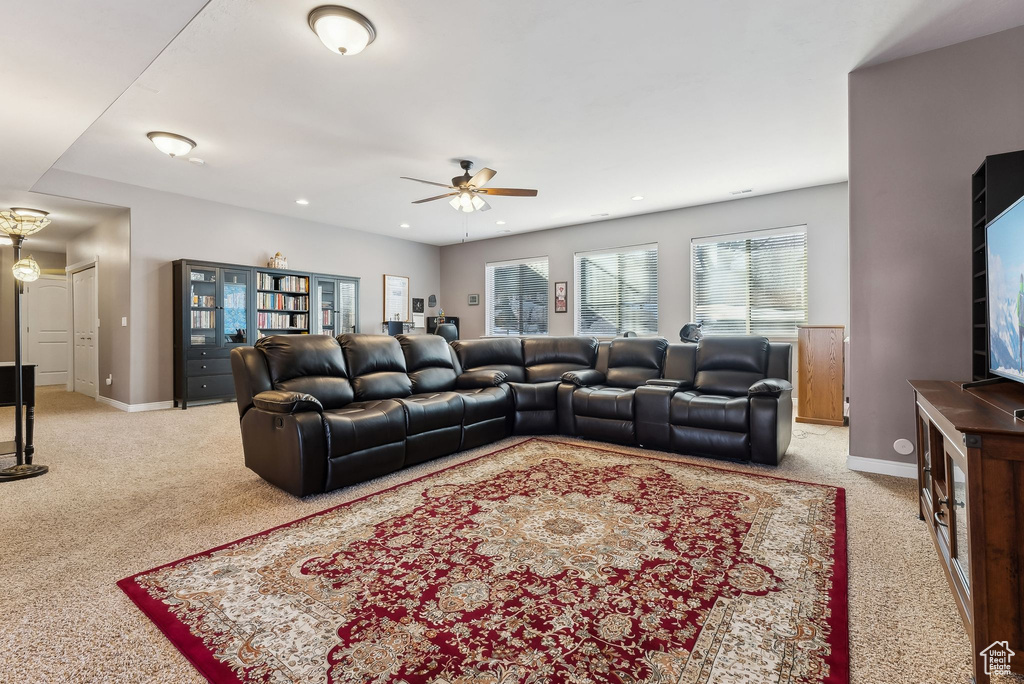 Living room featuring light carpet, ceiling fan, baseboards, and recessed lighting