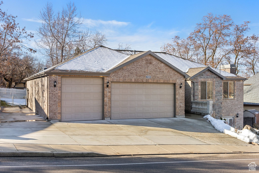 Ranch-style house featuring driveway, a garage, a chimney, and brick siding
