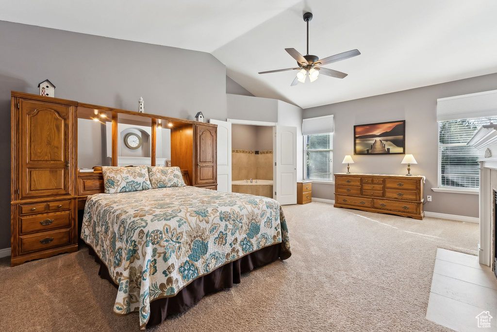 Bedroom with vaulted ceiling, multiple windows, baseboards, and light colored carpet