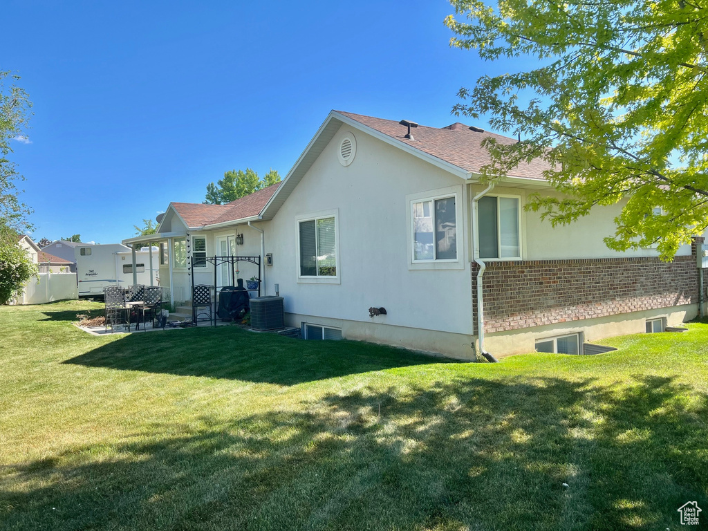 Back of property with central AC and roof with shingles