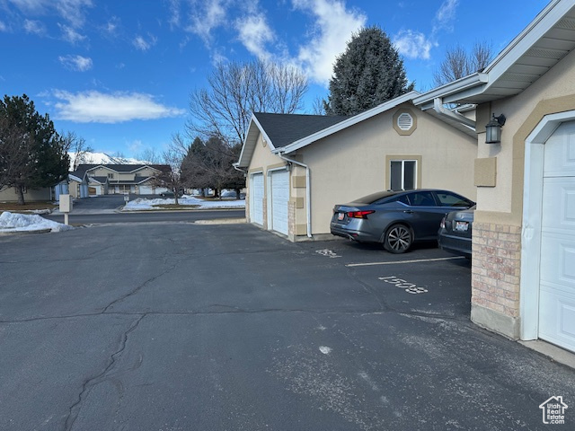 Exterior space with a garage and stucco siding