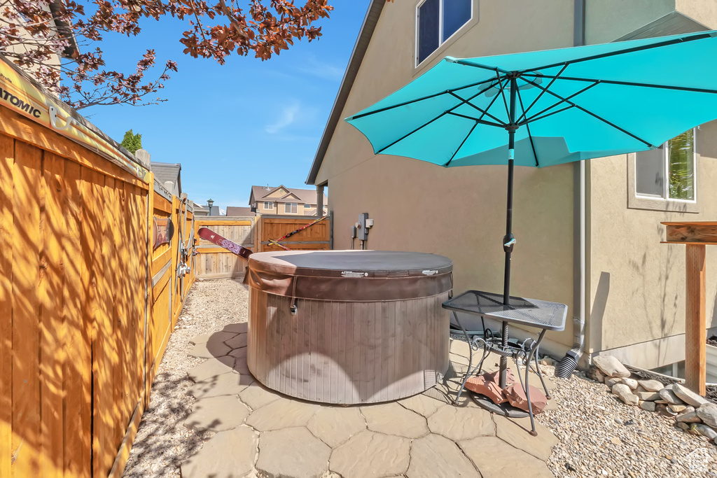 View of patio with a fenced backyard and a hot tub