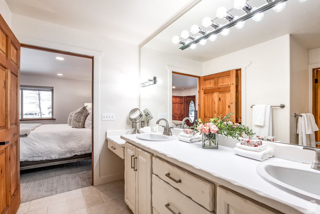 Ensuite bathroom featuring a sink, tile patterned floors, and ensuite bathroom
