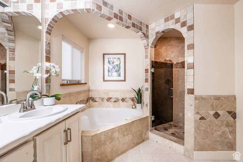 Full bath featuring tile patterned floors, a shower stall, a garden tub, and vanity