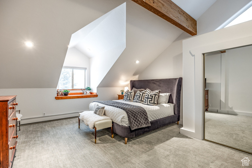 Carpeted bedroom with a closet, lofted ceiling with beams, a baseboard heating unit, and recessed lighting