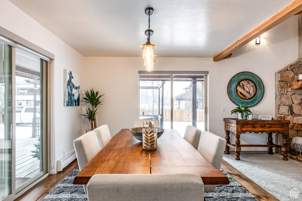 Dining space featuring a baseboard heating unit and beam ceiling